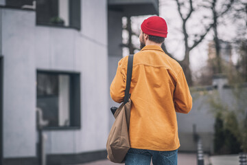 Man in an orange jacket walking down the street