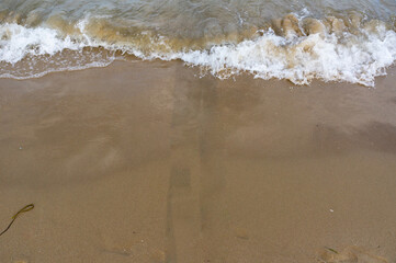 Sea surf, waves rolls on a sandy beach