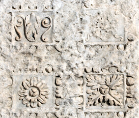 Ancient carved ornament with flower on a stone wall