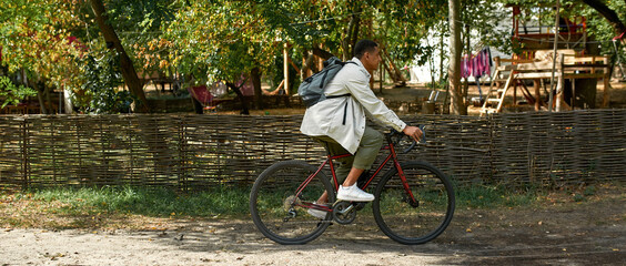 Young african american man riding bike sideways