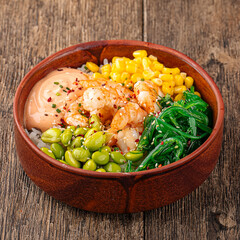 Hawaiian tuna poke bowl with vegetables on wooden background