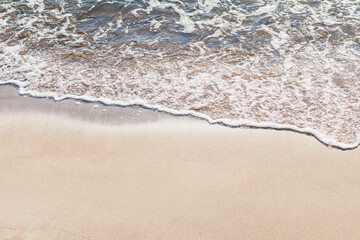 Fototapeta na wymiar Soft wave of the sea on the sandy beach.Soft focus,blurred image.