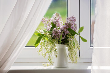 Beautiful vase with lilacs, white and purple on the window, nice light