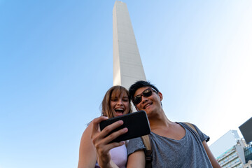 Young couple taking selfies at an attraction of a big city - 435339183
