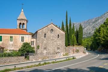 Fototapeta na wymiar Christian church near the road at sunny day in Makarska riviera, Croatia.
