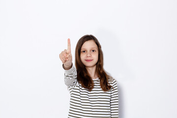 Funny dark-haired girl shows class gesture with her hands. On a light background. Space for text.
