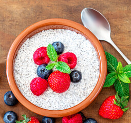 Chia seed pudding made with fruits and fresh  berries over wood background. Chia seeds Yogurt.