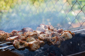 Shish Kebab skewer grill. Delicious background of roast pork, beef. The concept of summer outdoor recreation, picnic. Cooking meat on an open fire. Delicious crispy toasted barbecue. Atmospheric smoke
