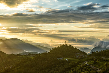 Fototapeta na wymiar Mountains under the light of sunrise through clouds
