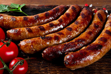  Grilled minced beef and pork sausages on wooden board close up