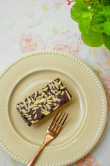 Homemade chocolate brownies in a golden yellow ceramic plate on the table, in a coffee shop,...
