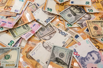 Money background from different countries dollars euro and hryvnia banknotes