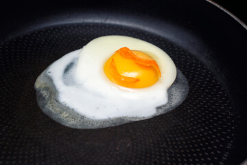 an egg in sunglasses and fried in a pan with a smile