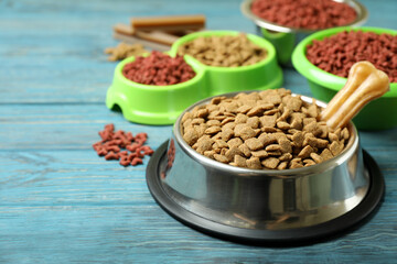 Bowls with pet feed on wooden background
