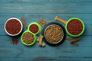 Bowls with pet feed on wooden background