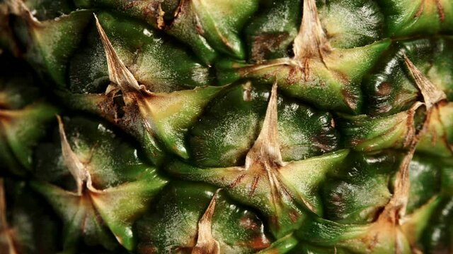 Close up of fresh pineapple ananas fruit skin as rotating food background. Healthy eating.