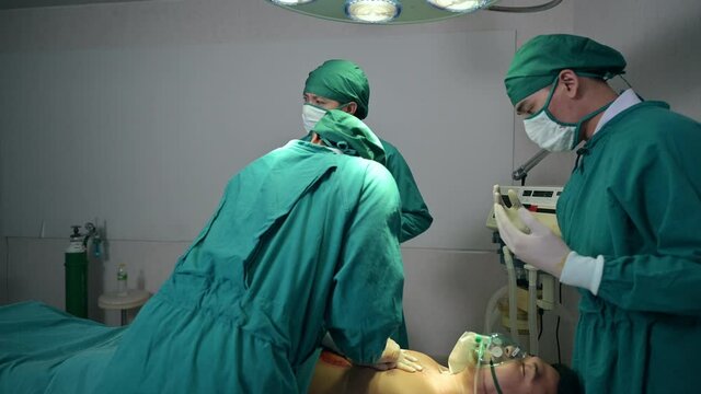 Team of doctor using defibrillator and CPR to help unconscious injured patient from serious accident in emergency ward