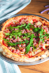 Pizza with seafood and arugula over rustic wooden background. Italian cuisine concept, Italian food.