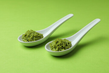 Ceramic spoons with wasabi on green background - obrazy, fototapety, plakaty