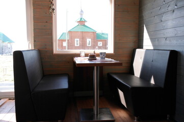 Fototapeta premium sofas and a table by the window in the dining area of the frame house