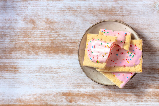 Strawberry pop tarts, shot from the top on a rustic wooden background with a place for text