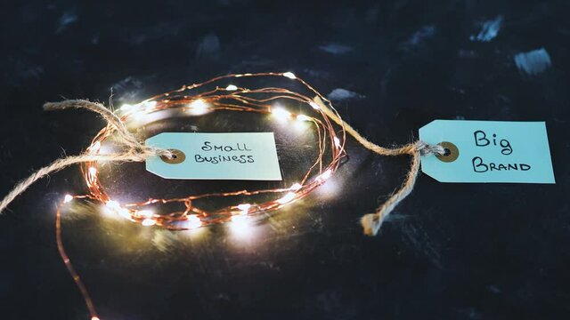 product tags with small business vs big brand texts with fairy lights on the small one, concept of customer behaviour and supporting small businesses