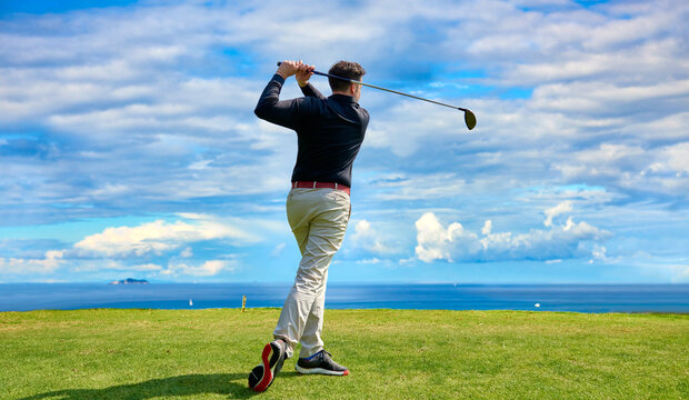 Golfer on the professional golf course. Golfer with golf club hitting the ball for the perfect shot.