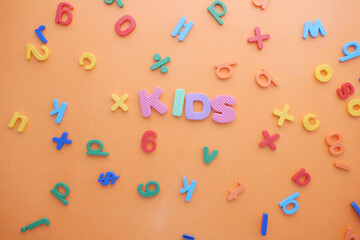 colorful plastic letters on orange background, Top view 