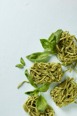 Green dry basil vegetarian pasta close up on blue background
