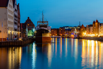 Gdansk night city riverside view with moored ship. View on famous facades of old medieval houses