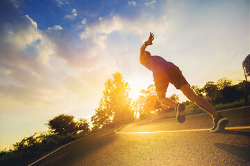 Silhouette of Young man running sprinting on road. Fit runner fitness runner during outdoor workout...