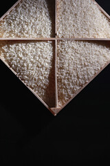 Fototapeta premium A set of grain cereals. Rice, buckwheat and millet groats in a wooden tray. A grocery set of cereals. Import of grain.