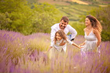 Happy family playing in lavender field.