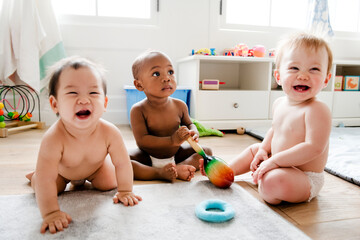 Babies playing together in a play room - obrazy, fototapety, plakaty