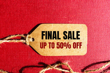 FINAL SALE UP TO 50 percent text on a brown tag on a red paper background
