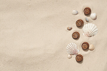 Fototapeta na wymiar barrels with numbers on the sand with shells for the summer sale