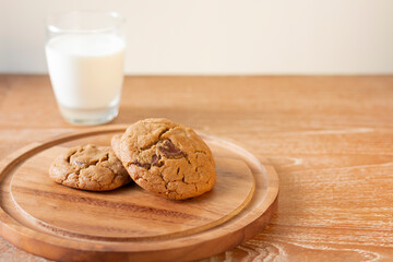 Delicious Chocolate Chip Cookies on wooden plate on wooden table. Fresh baked chocolate chip cookies on rustic wooden table. Homemade Chocolate Chip Cookies on a plate on a wooden table.