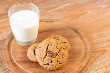 Delicious Chocolate Chip Cookies on wooden plate on wooden table. Fresh baked chocolate chip cookies on rustic wooden table. Homemade Chocolate Chip Cookies on a plate on a wooden table.