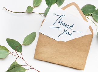 Card in an envelope mockup with leaves in the background