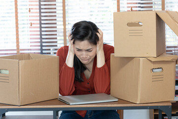 Female employee cried after losing her job during Covid-19 outbreak. Dejected fired office worker carrying a box full of belongings. Upset desperate female gets dismissal notice hiding crying face.