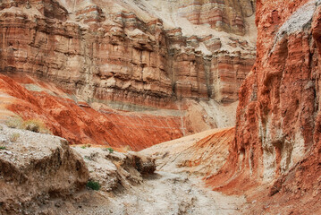 Canyon walls among ancient desert steppe fields, geological deposits of different times, clay, erosion. Rocky cliffs, hills and mountains in the Altyn-Emel park in Kazakhstan.