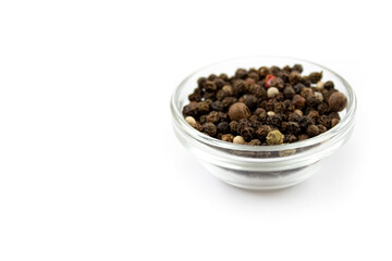 Pepper mix. Black, red and white peppercorns in a glass cup, isolated on white background. Close-up.