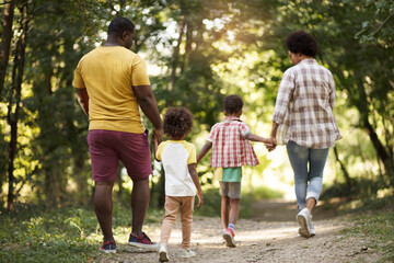  African American family walking trough park.