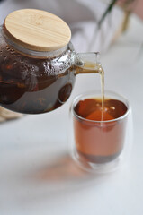 Tea pot male hand morning concept - transparent teapot in a man's hand on white backgrouhd morning routine man's care healthy lifestyle a man pours tea from a transparent teapot into a cup