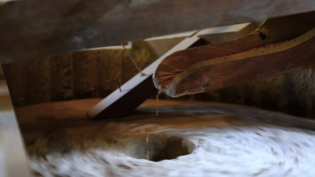 The ancient old stone grain mill gristmill grinding wheat or grains into flour using millstone quern stone in the serbian house
