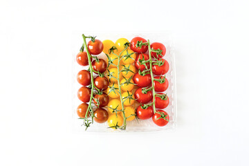 Freshness bunch of mix dark -orange, yellow-gold and red cherry-grape tomato with green branch on white background. Food nature sweet taste and  low acid .Vegetarien and appetizer idea.