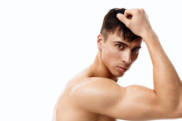 Fototapeta premium confident man athlete with a pumped-up torso touches his head with his hand