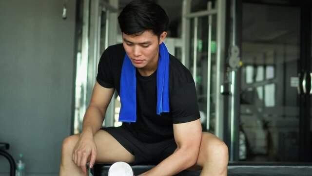 scene on young asian man holding dumbbell in hand for playing bicep  to gaining muscle at gym in the afternoon , healthy lifestyle concept	