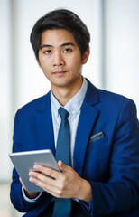20s young confident attractive Asian businessman wearing formal suit, standing and putting hand in pocket pants, holding tablet and looking at the camera. Showing modernity, startup, and technology.