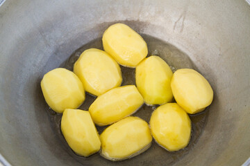 Golden potatoes are fried in boiling oil in a cauldron